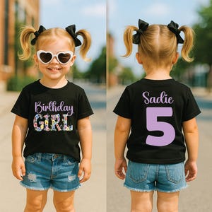 May include: A black short-sleeve t-shirt featuring the text Birthday Girl with floral lettering on the front and the name Sadie with the number 5 in large light purple font on the back, paired with blue denim shorts and heart-shaped sunglasses.
