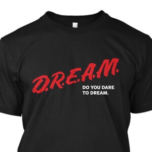 May include: Black t-shirt with red text that says "DREAM. DO YOU DARE TO DREAM."