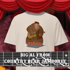 Könnte beinhalten: Weißes T-Shirt mit einer Cartoon-Illustration von Big Al aus Disneys Country Bear Jamboree. Big Al ist ein brauner Bär, der ein rotes Hemd und einen braunen Hut trägt und Gitarre spielt. Der Text "Big Al" ist unter der Illustration gedruckt.