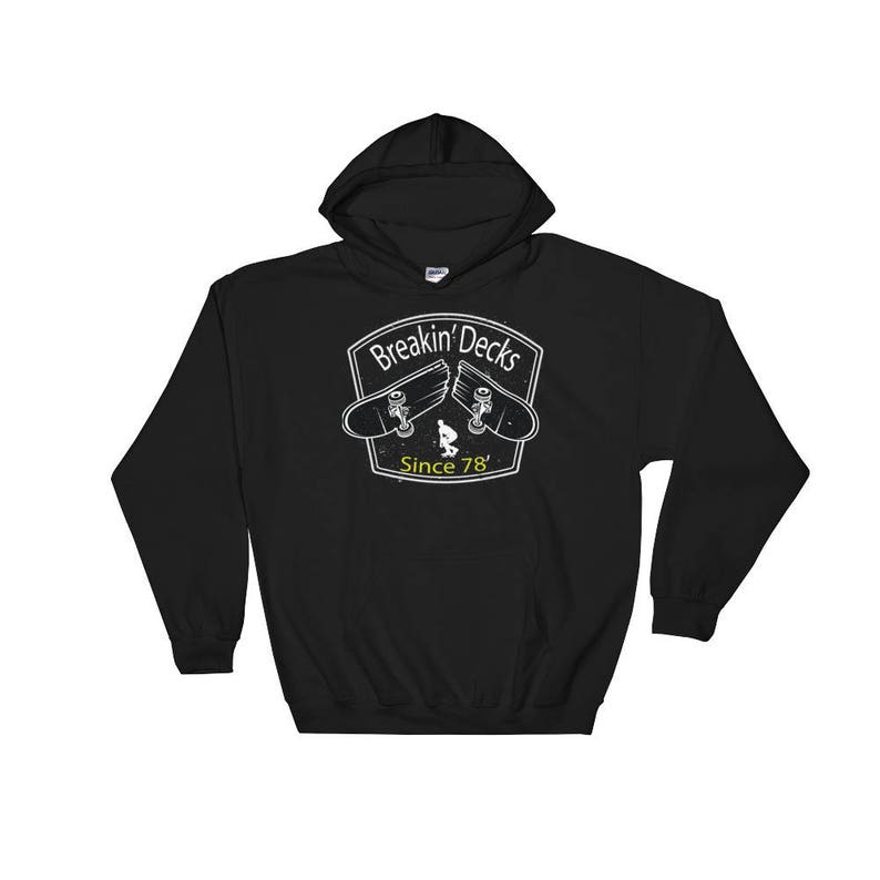 K&ouml;nnte beinhalten: Schwarzer Kapuzenpullover mit wei&szlig;er Grafik. Die Grafik zeigt ein zerbrochenes Skateboard-Design mit dem Text "Breakin' Decks" und "Since 78'". Der Kapuzenpullover hat eine Kapuze mit Kordelzug und eine K&auml;ngurutasche.