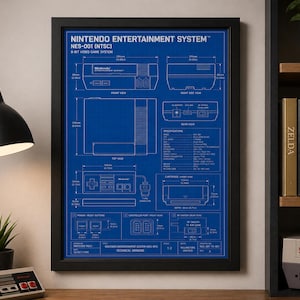 Puede incluir: Plano enmarcado de un sistema de entretenimiento Nintendo (NES-001). El plano azul incluye dibujos técnicos y especificaciones de la consola de videojuegos de 8 bits. El marco es negro.