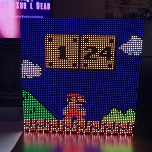 May include: A pixelated LED light display depicting a scene from Super Mario Bros. The display shows Mario, a timer reading 1:24, clouds, and a green and brown landscape against a blue backdrop.
