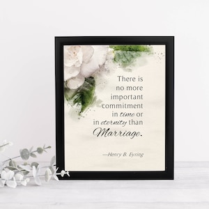 May include: A framed print with a black border features a watercolor floral design and the quote, "There is no more important commitment in time or in eternity than Marriage." The quote is attributed to Henry B. Eyring.