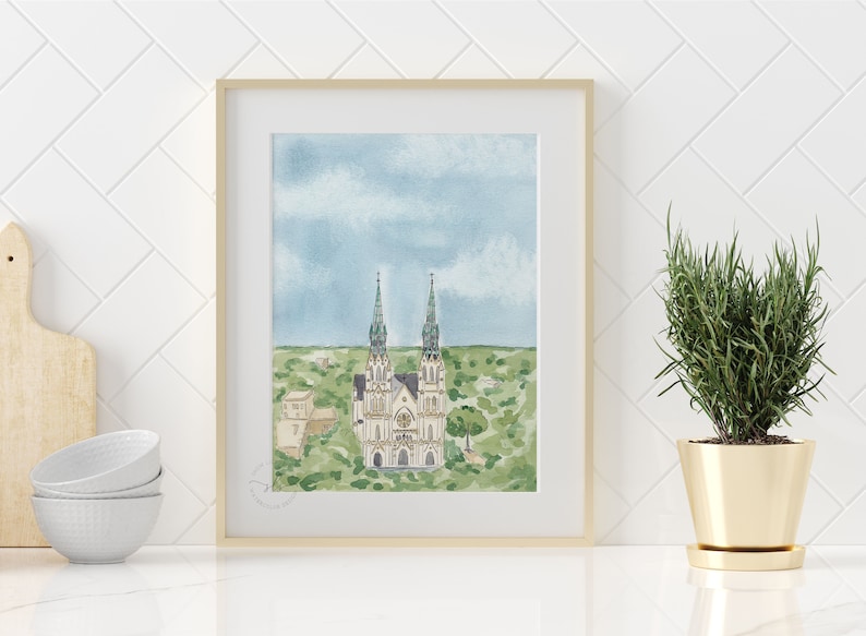 May include: Watercolor painting of a white church with two tall green spires, surrounded by green trees and a blue sky with white clouds.