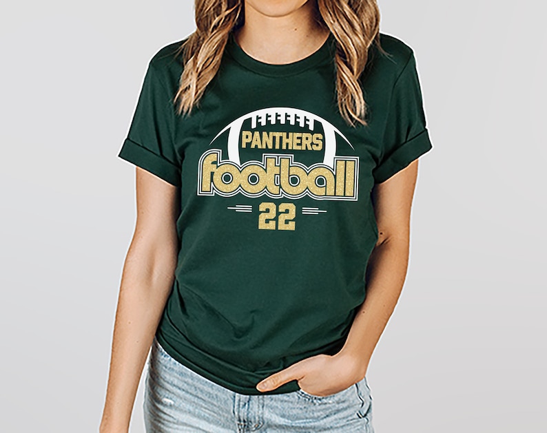 May include: A green t-shirt with a gold and white graphic that says "Panthers Football 22".