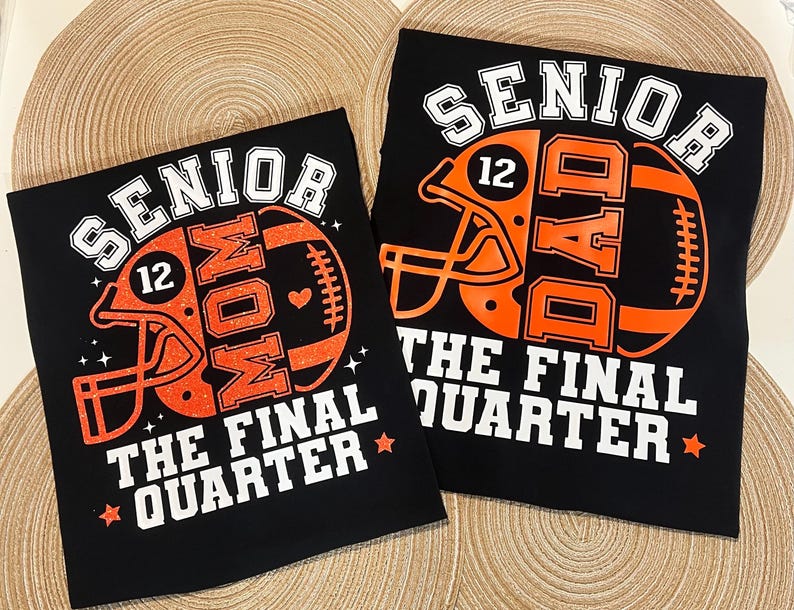 May include: Two black t-shirts featuring orange football helmet graphics with the number 12. One shirt reads SENIOR MOM and the other SENIOR DAD, both with the text THE FINAL QUARTER in white block letters and small star accents.