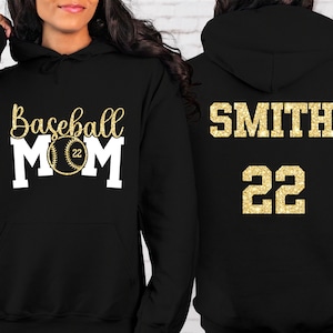 May include: Black hoodie with gold glitter text. The front says "Baseball Mom" with a baseball graphic. The back says "SMITH 22".
