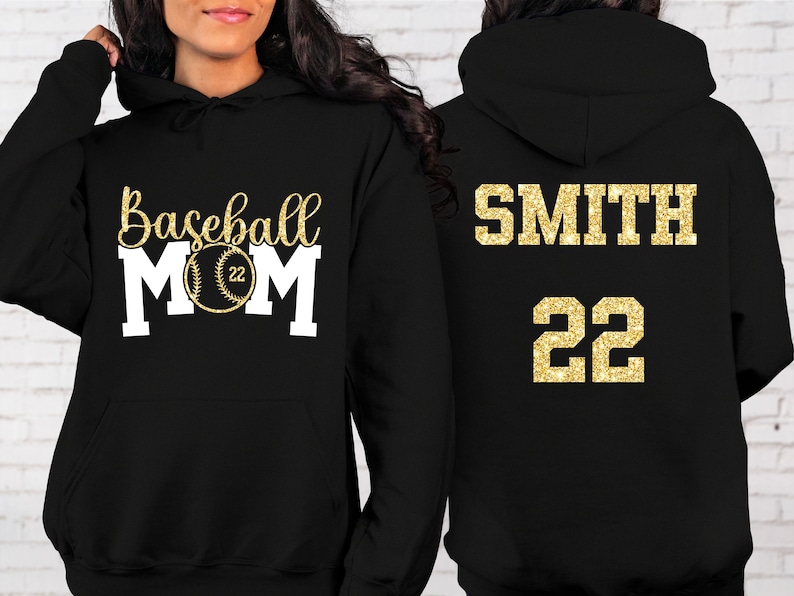 May include: Black hoodie with gold glitter text. The front says "Baseball Mom" with a baseball graphic. The back says "SMITH 22".