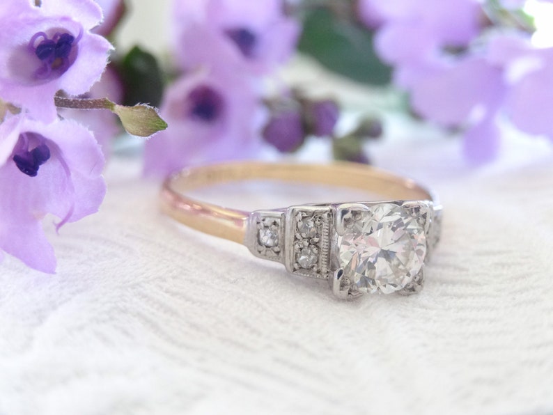 May include: A vintage engagement ring with a large, round, brilliant-cut diamond set in a platinum setting. The band is yellow gold.