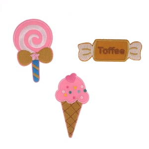 Puede incluir: Tres parches bordados para planchar que representan una piruleta rosa, un cono de helado rosa y una barra de caramelo marrón con la palabra "Toffee" en ella.