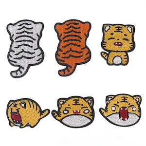 Puede incluir: Conjunto de seis parches bordados para planchar con diferentes diseños de tigres de dibujos animados. Los parches son de varios colores, incluyendo naranja, amarillo, blanco y negro.