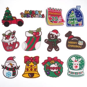 Pode incluir: Um conjunto de 10 patches termocolantes com tema natalino. Os patches apresentam vários designs festivos, incluindo um boneco de neve, um homem de gengibre, uma meia, um sino, uma coroa, um globo de neve, uma casa, um calendário, uma bolsa e uma árvore de Natal. Os patches são todos bordados com fio colorido e têm um fundo branco.