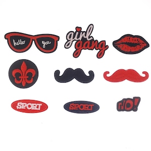 May include: Assortment of iron-on patches featuring various designs, including a pair of sunglasses with the words "hello you", a red lip, a black mustache, a red mustache, a fleur-de-lis, two oval patches with the word "sport" in white, a red and white patch with the words "girl gang", and a red and white patch with the words "r'o!"