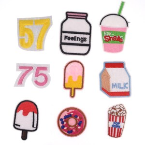 May include: Set of ten embroidered iron-on patches featuring various designs, including numbers, a milk carton, a donut, a popsicle, a milkshake, a jar labeled "Feelings", and a popcorn container.