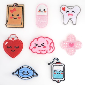Pode incluir: Conjunto de 9 patches bordados para passar a ferro com adoráveis personagens de desenhos animados com caras felizes. Os patches incluem um coração, um cérebro, um dente, uma pílula, uma bandagem, uma prancheta e um saco de soro.