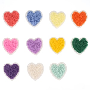May include: Twelve fuzzy heart-shaped patches in various colors, including pink, purple, blue, green, orange, yellow, and white. The patches are all the same size and shape, and they are arranged in a grid pattern.