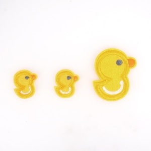 May include: Three yellow felt embroidered duck patches of different sizes. The largest duck is about 5 cm tall and the smallest duck is about 2.5 cm tall.
