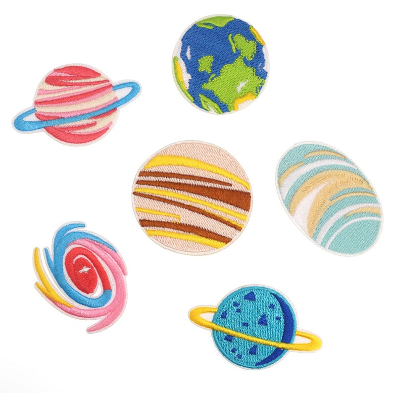 May include: Set of six embroidered iron-on patches featuring planets in various colors and designs. The patches include a blue and green Earth, a pink and white striped planet with a ring, a brown and yellow striped planet, a blue and white striped planet, a pink and blue swirl, and a blue planet with a ring.