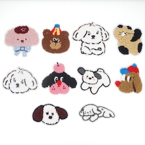 May include: Ten colorful embroidered iron-on patches featuring various animal designs, including dogs, cats, and a bear. The patches are made of fluffy fabric and have a variety of colors and patterns.