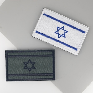 May include: Two embroidered patches depicting the Israeli flag. One has a white background with blue stripes and a blue Star of David. The other has a dark green background with a dark blue Star of David and border.