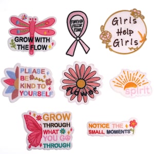 May include: Nine embroidered iron-on patches with various designs and phrases, including "Grow with the Flow", "Forever Feelin Fine", "Girls Help Girls", "Please Be Kind to Yourself", "Spirit", "Grow Through What You Go Through", "Notice the Small Moments", and "Flower".