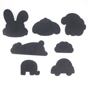 May include: A set of seven black felt cutouts of various animals and objects, including a bunny, a dog, a cloud, a car, an elephant, and two sleeping animals.