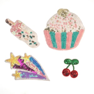 Könnte beinhalten: Vier bunte Bügelbilder mit einem Cupcake, einem Eis am Stiel, einem Sternschnuppen und einer Kirsche. Die Patches sind aus Pailletten gefertigt und eignen sich perfekt, um Kleidung, Taschen oder anderen Accessoires einen Hauch von Verspieltheit zu verleihen.