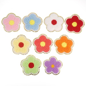 May include: Ten colorful felt flower patches with gold glitter trim. Each flower has five petals and a yellow center.