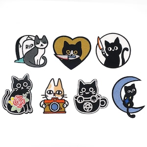 May include: Set of 8 iron-on patches featuring black cats in various poses and settings. The patches include a cat in a coffin, a cat with a knife, a cat in a coffee cup, a cat in a crescent moon, and a cat with a camera.