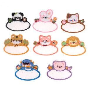 May include: Set of ten colourful embroidered iron-on patches featuring cute animal designs with blank spaces for adding text. The patches are perfect for personalising clothing, bags, and other accessories.