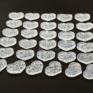 May include: Set of 30 clear heart-shaped silicone moulds with various designs, including letters, animals, stars, flowers, and geometric shapes.
