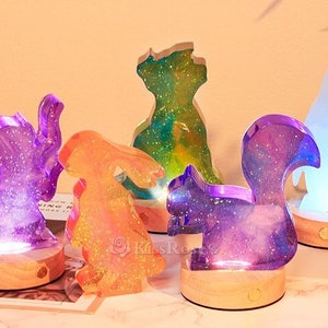 May include: Five resin animal night lights with glitter embedded in the resin. The animals are a cat, a rabbit, a squirrel, a penguin, and a dog. Each animal is on a wooden base with a light switch on the bottom.