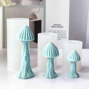 Könnte beinhalten: Drei Silikonformen zum Herstellen von Pilz-förmigen Dekorationen. Die Formen sind klar und haben eine glatte Oberfläche. Die Pilze sind hellblau und haben einen strukturierten Stiel.