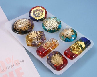 May include: A silicone mold for making resin jewelry featuring eight different shapes, including a flower of life, a star, and a square. The mold is white and has a smooth surface. The resin pieces are colorful and have gold accents.