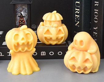 May include: Three Halloween-themed pumpkin candles, one shaped like a ghost holding a pumpkin, one with a traditional pumpkin shape, and one with a pumpkin shape and a hat on top. The candles are all a light orange color.