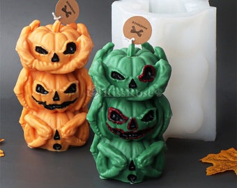 Puede incluir: Dos moldes de velas de calabaza de Halloween, uno verde y otro naranja, con el texto "Handmade" en una etiqueta marrón. Los moldes están apilados con tres calabazas cada uno, y la calabaza de arriba tiene una cara de miedo.