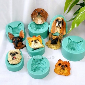 May include: Set of 9 silicone molds for making dog head shaped cake toppers. The molds are teal green and feature different dog breeds, including a Yorkshire Terrier, a Chihuahua, a Beagle, and a Golden Retriever.