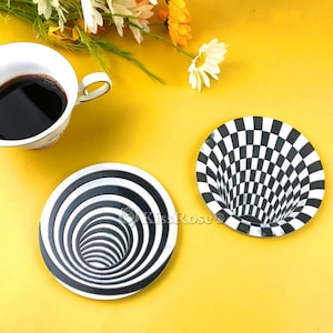 May include: Two black and white optical illusion plates. One plate has a checkerboard pattern that creates a swirling effect. The other plate has concentric circles that create a tunnel effect.