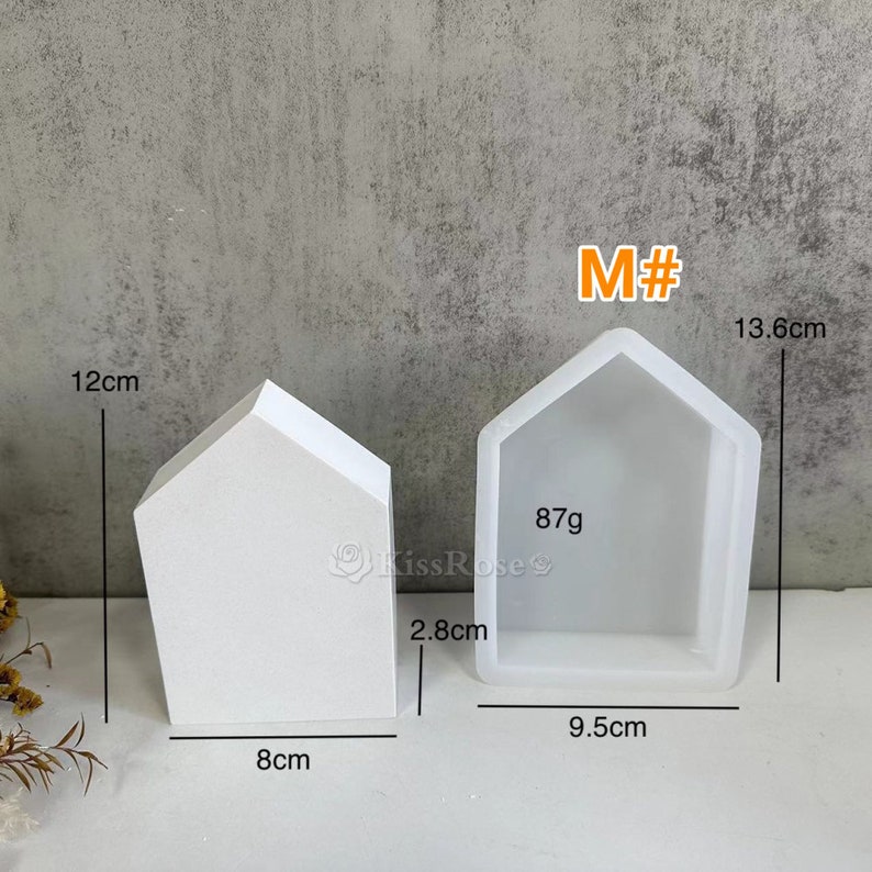 K&ouml;nnte beinhalten: Wei&szlig;e Silikonform in Form eines Hauses mit den Ma&szlig;en: 13,6 cm hoch, 9,5 cm breit, 8 cm tief und 2,8 cm hoch. Die Form wiegt 87 Gramm. M# ist auf der Form geschrieben.