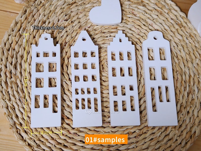 May include: Four white wooden house-shaped ornaments with cut-out windows. The ornaments are 13 cm tall and 3.7 cm wide. The thickness is 0.7 cm. 01#samples