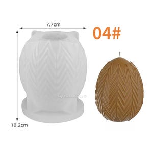 May include: White silicone mold for making a candle in the shape of a textured egg. The mold is 7.7 cm wide and 10.2 cm tall. The finished candle is shown in brown.