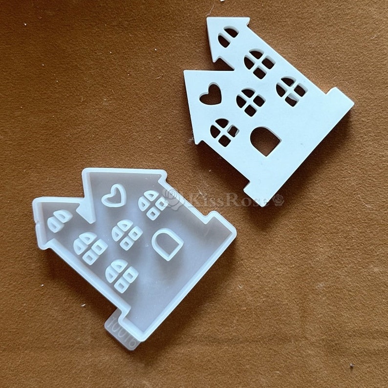 Puede incluir: Dos moldes de pl&aacute;stico blanco con forma de casas con ventanas y corazones. Los moldes est&aacute;n dise&ntilde;ados para hacer galletas u otras golosinas.
