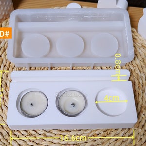 May include: White silicone mold for making three small candles. The mold is 16.6 inches long, 4 inches wide, and 0.8 inches tall. The mold has three round cavities for the candles, each with a diameter of 4 inches.