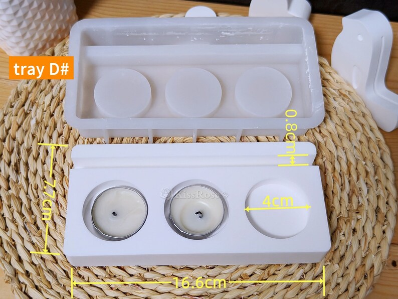 May include: White silicone mold for making three small candles. The mold is 16.6 inches long, 4 inches wide, and 0.8 inches tall. The mold has three round cavities for the candles, each with a diameter of 4 inches.