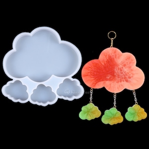 Puede incluir: Molde de silicona para hacer un colgante de resina en forma de nube con tres nubes más pequeñas colgando de él. El molde es blanco y el colgante es naranja con detalles verdes.