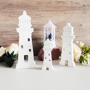 Puede incluir: Tres figuritas de faro de madera blanca de diferentes tamaños. El faro más grande mide 25 cm de alto, el faro del medio mide 15 cm de alto y el faro más pequeño mide 10 cm de alto. Los faros están todos pintados de blanco y tienen un diseño simple.