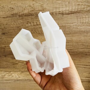 以下が含まれることがあります： 幾何学的な形を作るための白いシリコンモールド。モールドが開いており、モールドの内側が見える。