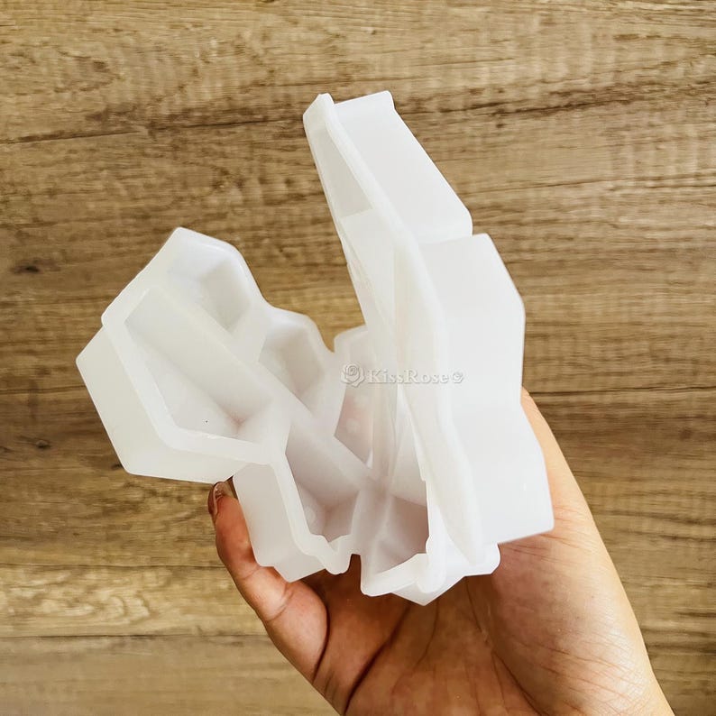 以下が含まれることがあります： 幾何学的な形を作るための白いシリコンモールド。モールドが開いており、モールドの内側が見える。