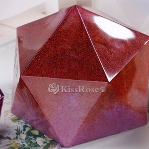 K&ouml;nnte beinhalten: Eine rote, glitzernde, geometrische Harzform in Form eines Dodekaeders. Die Form besteht aus klarem Harz und hat eine gl&auml;nzende, irisierende Oberfl&auml;che. Die Form ist perfekt f&uuml;r die Herstellung einzigartiger und dekorativer Harzhandwerke.
