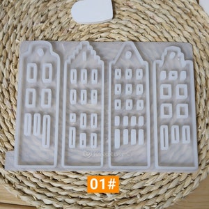 May include: A silicone mold with four separate sections, each shaped like a house with multiple windows. The mold is white and has a smooth surface. The text "01#" is printed on the bottom of the mold.